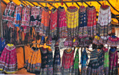 there are many colorful dresses hanging on a rack