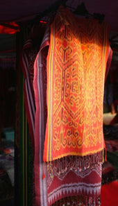 a red and yellow scarf hanging on a rack