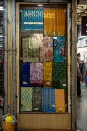 A store front with a display of colorful fabrics