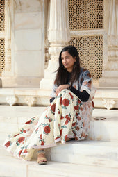 Woman poses on steps of ornate white building.