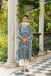 Woman poses elegantly in a beautiful patterned outfit.