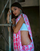 a woman wearing a pink and white sari
