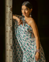 a woman in a dress leaning against a wall