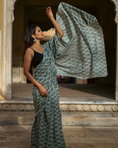 a woman in a sari holding up a piece of cloth