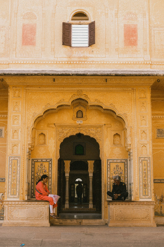 a person sitting on a bench in front of a building
