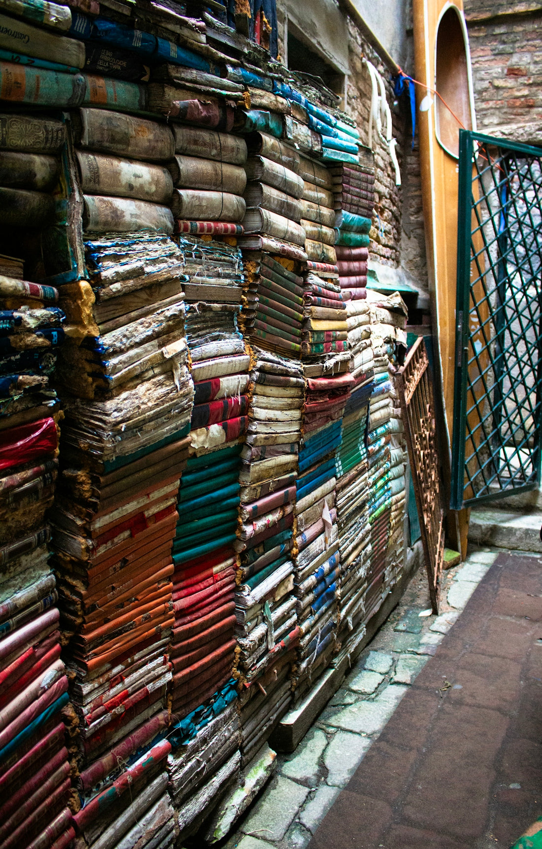 A narrow alleyway with a large amount of fabrics on display