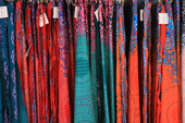 A rack of colorful scarves in a store