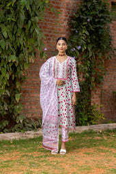 Woman models a floral indian suit with a dupatta.