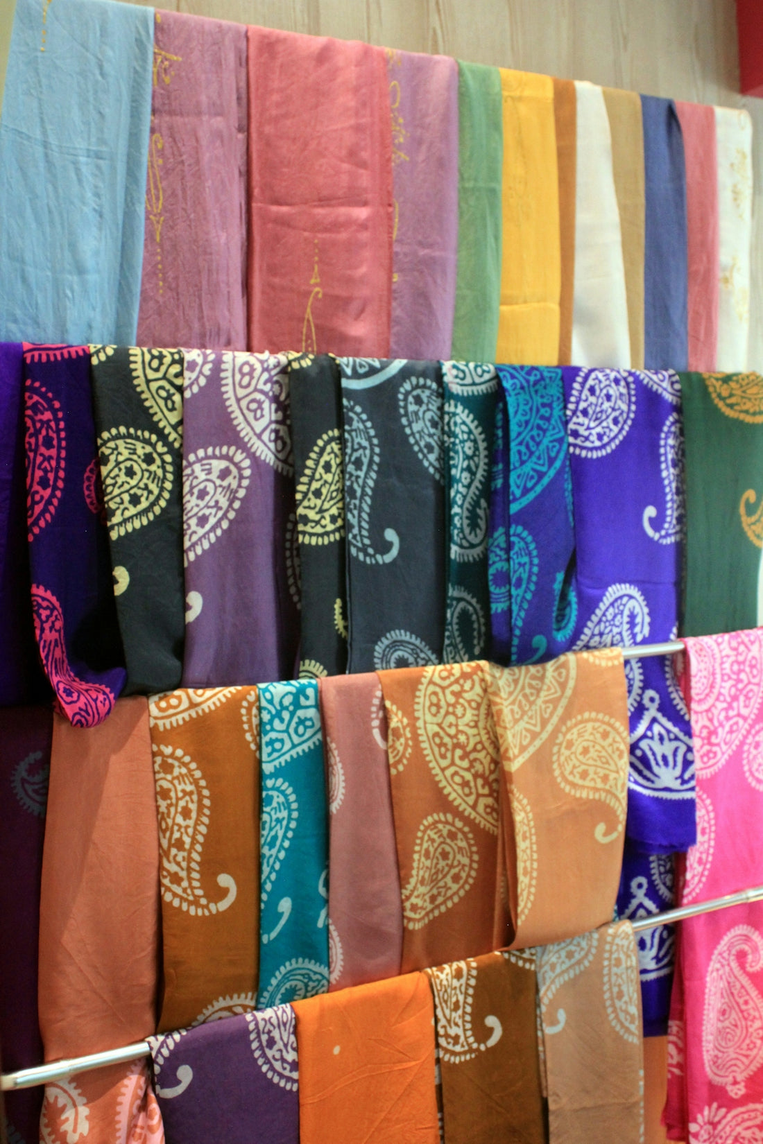 Colorful scarves with paisley patterns are on display.