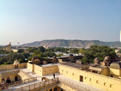Rooftops and distant mountains under a clear sky.