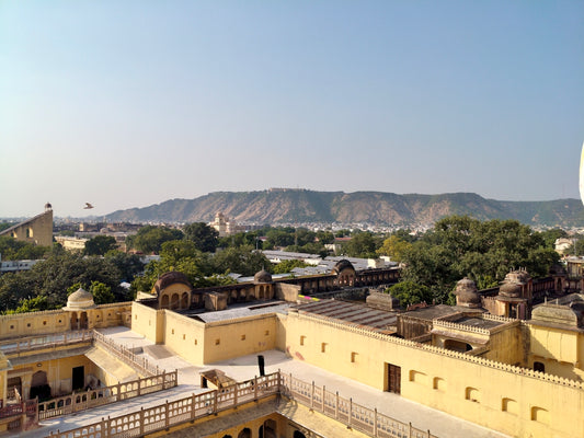 Rooftops and distant mountains under a clear sky.